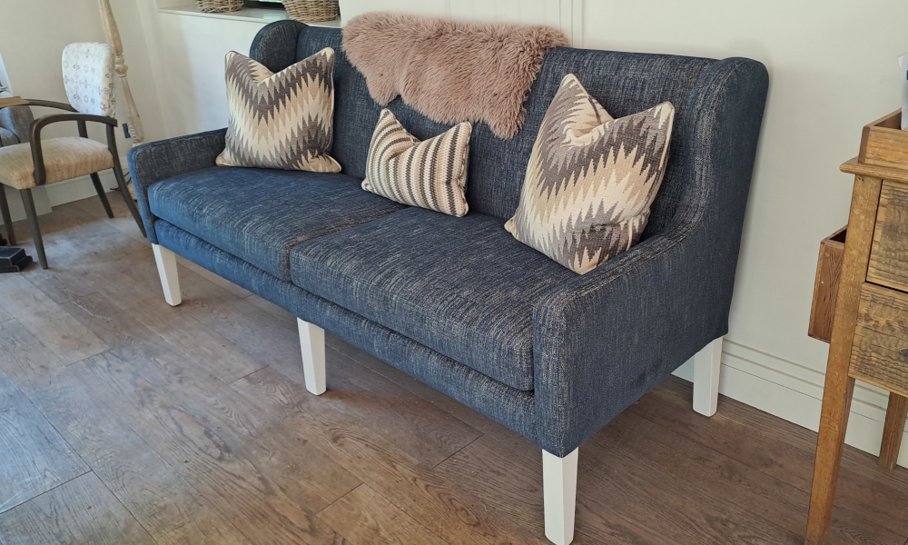 A blue 3-seater sofa with a wing back and removable seat cushions.